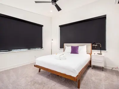 a bedroom with a white bed and a large screen at Historic German Village Industrial Masterpiece in Columbus