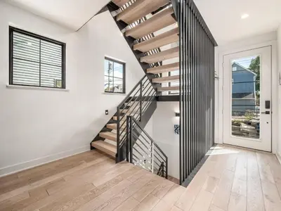 a staircase in a home with white walls and wood floors at Historic German Village Industrial Masterpiece in Columbus