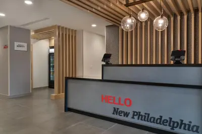 a hotel lobby with a hello new philadelphia reception desk at TownePlace Suites by Marriott New Philadelphia in New Philadelphia