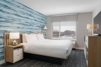 a hotel room with a large bed and a large mural at TownePlace Suites by Marriott New Philadelphia in New Philadelphia