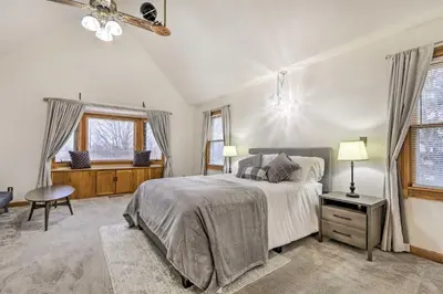 a bedroom with a bed and a desk and windows at Natures Haven Farmhouse in Pickerington with Deck in Pickerington
