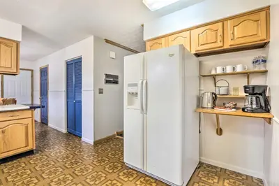 a kitchen with a white refrigerator and wooden cabinets at Natures Haven Farmhouse in Pickerington with Deck in Pickerington