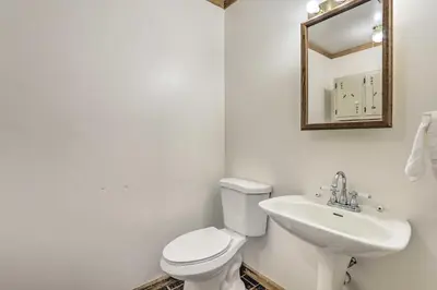 a bathroom with a toilet and a sink and a mirror at Natures Haven Farmhouse in Pickerington with Deck in Pickerington