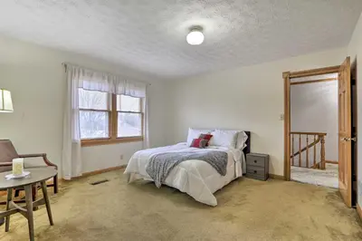 a bedroom with a bed and a table and a window at Natures Haven Farmhouse in Pickerington with Deck in Pickerington