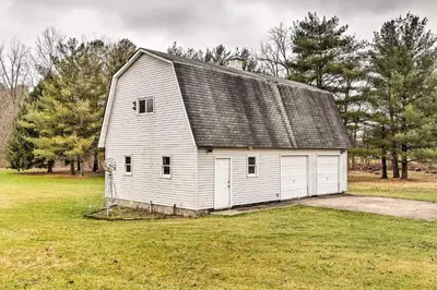 an old white barn in a field with trees at Natures Haven Farmhouse in Pickerington with Deck in Pickerington