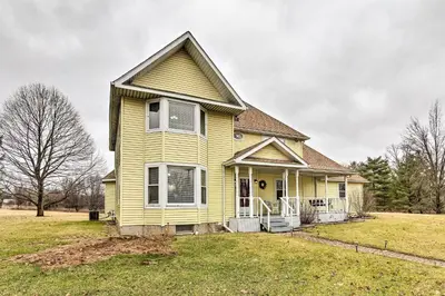 a yellow house on a grassy field at Natures Haven Farmhouse in Pickerington with Deck in Pickerington