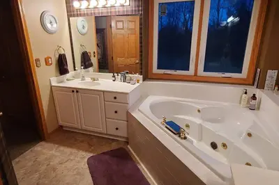 a bathroom with a large tub and a sink at House On Grass Runway with Fly-In/Fly-Out Access in Tecumseh
