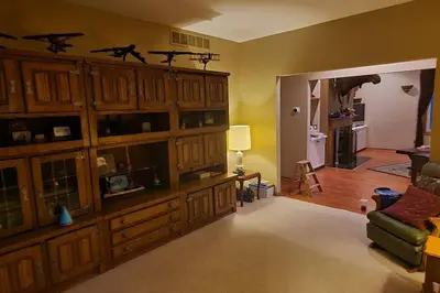 a living room with a large wooden entertainment center at House On Grass Runway with Fly-In/Fly-Out Access in Tecumseh