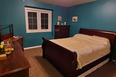 a bedroom with a bed and a table and a window at House On Grass Runway with Fly-In/Fly-Out Access in Tecumseh