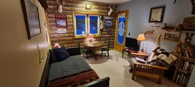 a living room with wooden walls and a table in a room at House On Grass Runway with Fly-In/Fly-Out Access in Tecumseh