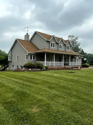 a large house with a large green lawn at House On Grass Runway with Fly-In/Fly-Out Access in Tecumseh
