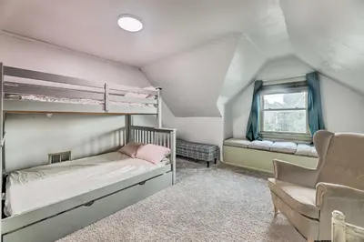 a bedroom with two bunk beds and a chair at NEW Grand Historic Home - 4 Mi to WEC! in Wilmington