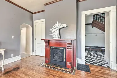 a living room with a fireplace and a staircase at NEW Grand Historic Home - 4 Mi to WEC! in Wilmington
