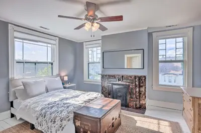 a bedroom with a bed with a fireplace and a ceiling fan at NEW Grand Historic Home - 4 Mi to WEC! in Wilmington