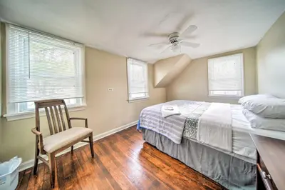 a bedroom with a bed and a chair and windows at Eastlake Home with Patio Less Than 1 Mi to Lake Erie! in Eastlake