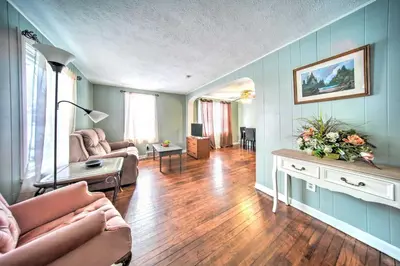 a living room with blue walls and wooden floors at Eastlake Home with Patio Less Than 1 Mi to Lake Erie! in Eastlake