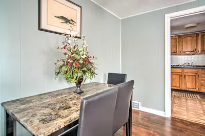 a dining room table with chairs and a vase of flowers at Eastlake Home with Patio Less Than 1 Mi to Lake Erie! in Eastlake