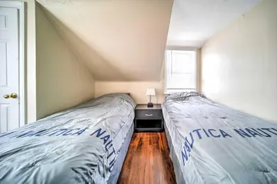 two beds in a small bedroom with a window at Eastlake Home with Patio Less Than 1 Mi to Lake Erie! in Eastlake