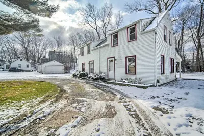 a white house with snow on the ground at Eastlake Home with Patio Less Than 1 Mi to Lake Erie! in Eastlake