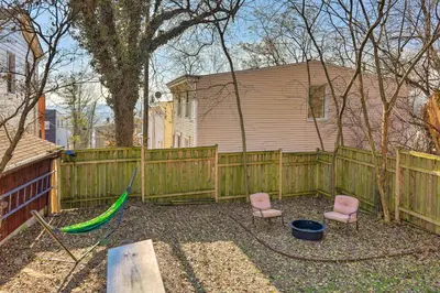 a backyard with a wooden fence and a hammock at Cincinnati Home with Deck and Private Hot Tub! in Cincinnati