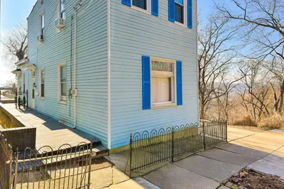 a blue house with a window and a fence at Cincinnati Home with Deck and Private Hot Tub! in Cincinnati