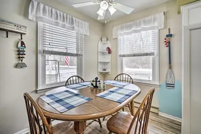 a dining room with a table and chairs and windows at Waterfront Lakeview Cottage with Dock and Lift! in Lakeview