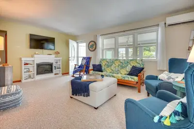 a living room with blue furniture and a fireplace at Waterfront Lakeview Cottage with Dock and Lift! in Lakeview