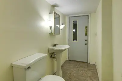 a bathroom with a toilet and a sink and a mirror at Cincinnati Home, Patio with Downtown Views! in Cincinnati