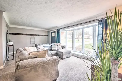 a living room with a couch and a large window at Cozy Ohio Retreat with Deck, Hot Tub and Grill! in Broadview Heights
