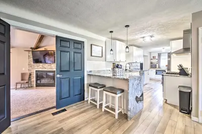 a kitchen with a blue door and a counter with stools at Cozy Ohio Retreat with Deck, Hot Tub and Grill! in Broadview Heights