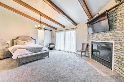 a bedroom with a fireplace and a tv on a brick wall at Cozy Ohio Retreat with Deck, Hot Tub and Grill! in Broadview Heights