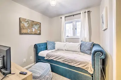 a living room with a blue couch and a window at Cozy Ohio Retreat with Deck, Hot Tub and Grill! in Broadview Heights
