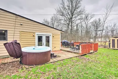 a hot tub on a deck next to a house at Cozy Ohio Retreat with Deck, Hot Tub and Grill! in Broadview Heights