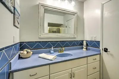 a bathroom with a blue sink and a mirror at Vermilion River Home with Hot Tub and Private Dock! in Vermilion