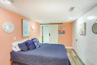 a bedroom with orange walls and a bed with purple pillows at Vermilion River Home with Hot Tub and Private Dock! in Vermilion