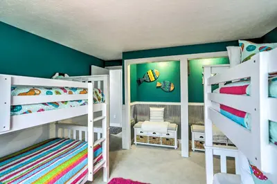 a kids room with two bunk beds and a green wall at Vermilion River Home with Hot Tub and Private Dock! in Vermilion