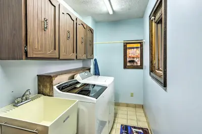 a small kitchen with a washing machine and a sink at Vermilion River Home with Hot Tub and Private Dock! in Vermilion