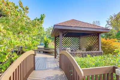 a wooden bridge with a gazebo in a garden at Vermilion River Home with Hot Tub and Private Dock! in Vermilion
