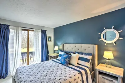 a bedroom with a bed with blue walls and a window at Vermilion River Home with Hot Tub and Private Dock! in Vermilion