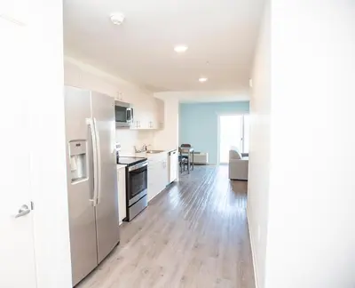 a kitchen with a stainless steel refrigerator and a table at THE NEST in Greenfield