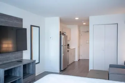 a living room with a television and a kitchen at THE NEST in Greenfield