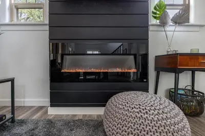 a fireplace in a living room with a fire place at The Akron Retreat: Modern 3-Bedroom Oasis in Akron