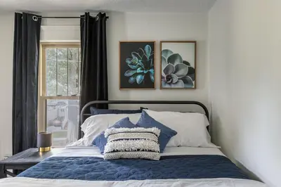 a bedroom with a blue and white bed with a window at The Akron Retreat: Modern 3-Bedroom Oasis in Akron