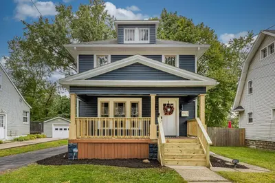 a house with a porch with a front door at The Akron Retreat: Modern 3-Bedroom Oasis in Akron