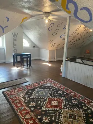 a room with a rug on the floor and a table at Awesome Attic Studio Private Room 3A in Cincinnati