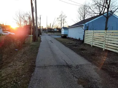 a dirt road with a fence and a house at Lovely Two Bedroom Home- Close to DT Greenfield in Greenfield