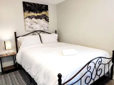 a bedroom with a white bed with a black frame at Lovely Two Bedroom Home- Close to DT Greenfield in Greenfield