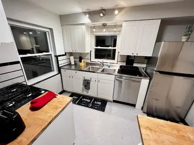a kitchen with white cabinets and stainless steel appliances at Comfy 2nd Floor Apartment in Quiet Neighborhood 13 Min to Dwntwn in Cincinnati