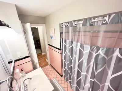 a bathroom with a shower curtain and a sink at Comfy 2nd Floor Apartment in Quiet Neighborhood 13 Min to Dwntwn in Cincinnati