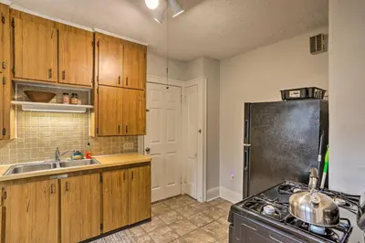 a kitchen with wooden cabinets and a sink and a stove at Lakewood Home with Yard about 8 Mi to Cleveland! in Lakewood